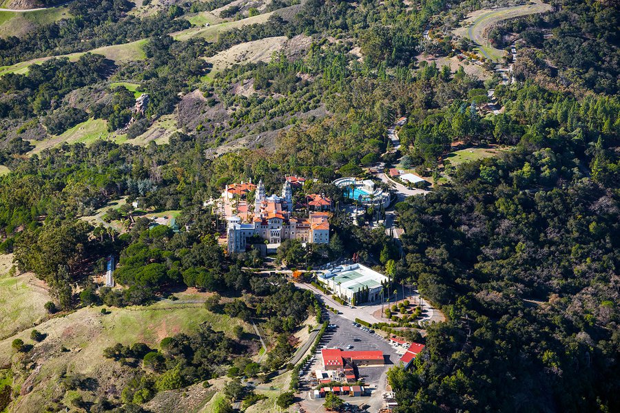 An aerial photograph of Hearst Castle showcases the grandiose and magnificent estate, located on a hilltop overlooking the Pacific Ocean in San Simeon, California