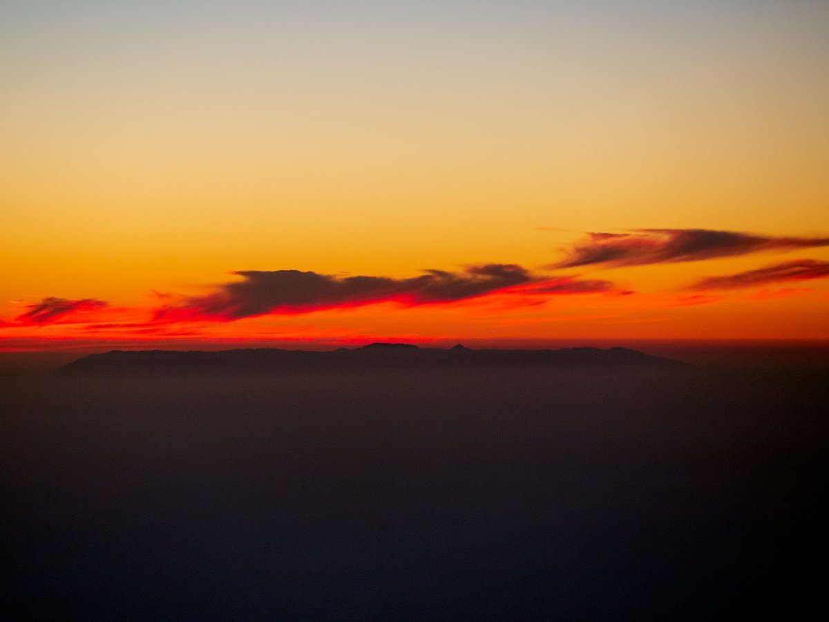 Blog image of Santa Catalina Island at sunset with the clouds colored bright reds and oranges