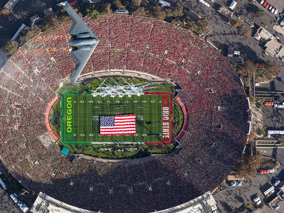 Aerial view of the B-2 Spirit flying over the 2025 Rose Bowl Game at the conclusion of the National Anthem, with the Oregon Marching Band on the field below holding an American flag at the Rose Bowl Stadium, in Pasadena, California.