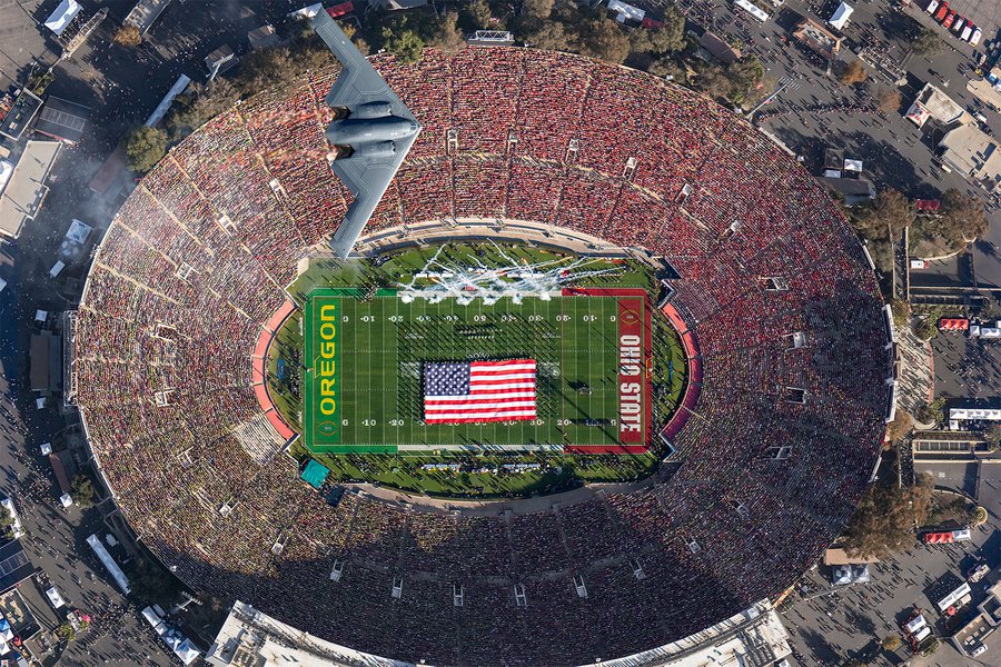 Aerial view of the B-2 Spirit flying over the 2025 Rose Bowl Game at the conclusion of the National Anthem, with the Oregon Marching Band on the field below holding an American flag at the Rose Bowl Stadium, in Pasadena, California.